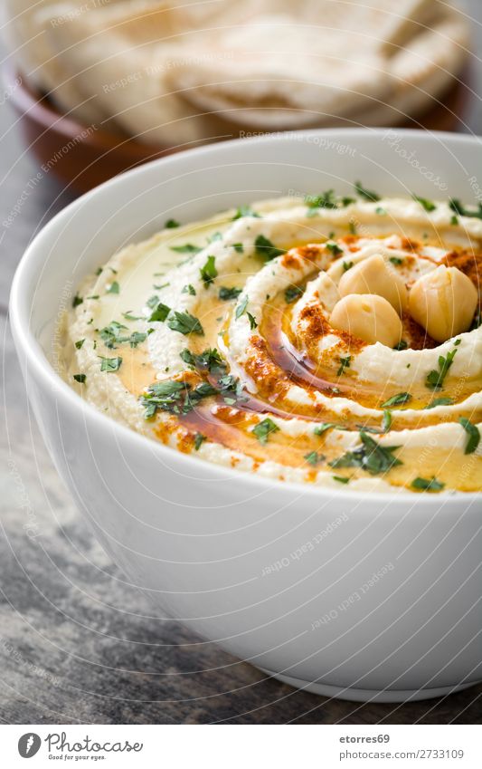 Hummus in der Schüssel und Pita-Brot auf Holztisch. Lebensmittel Gesunde Ernährung Foodfotografie Speise Kichererbsen Koriander Zitrone Olivenöl