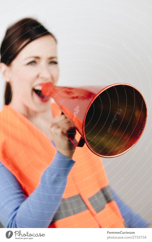 Woman in warning vest making announcement with megaphone feminin 1 Mensch 18-30 Jahre Jugendliche Erwachsene 30-45 Jahre Kommunizieren Streik fordern