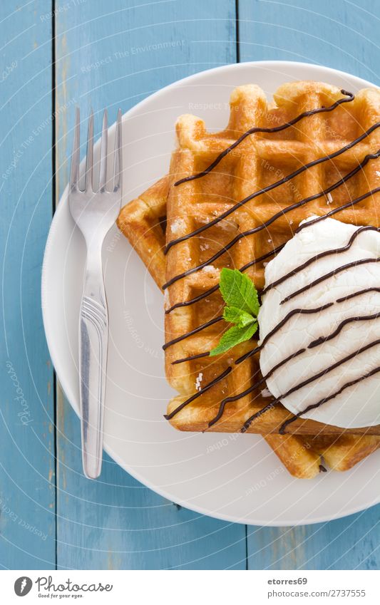 Belgische Waffeln mit Eis auf blauem Holztisch. Dessert Speiseeis Belgier Belgien weiß süß Lebensmittel Gesunde Ernährung Foodfotografie Hintergrund neutral