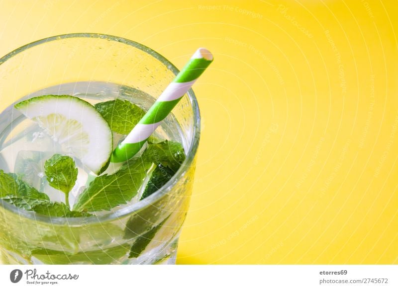 Mojito-Cocktail im Glas auf gelbem Hintergrund Getränk trinken Alkohol Erfrischung Sommer Kalk grün Minze Saft Rum kalt Eis Mischmaschine Frucht Zutaten Zucker