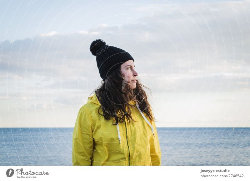 Brünette Frau am Strand Lifestyle Leben Erholung Ausflug Freiheit Sonne Winter Sport Sitzung 30-45 Jahre Erwachsene Natur Horizont Küste Mode Jacke Mantel Hut