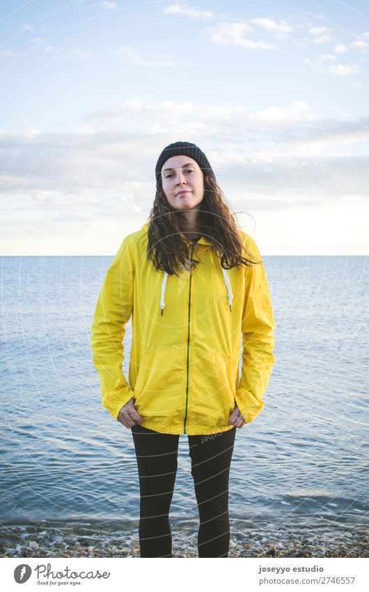 Junge Frau am Strand Lifestyle Leben Erholung Ausflug Freiheit Sonne Winter Sport Sitzung 30-45 Jahre Erwachsene Natur Horizont Küste Platz Mode Jacke Mantel