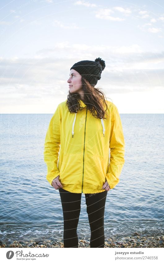 Frau am Strand im Winter Lifestyle Leben Erholung Ausflug Freiheit Sonne Sport Sitzung 30-45 Jahre Erwachsene Natur Horizont Küste Mode Jacke Mantel Hut Lächeln