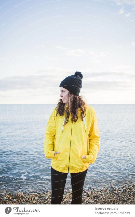 Frau am Strand im Winter Lifestyle Leben Erholung Ausflug Freiheit Sonne Sport Sitzung 30-45 Jahre Erwachsene Natur Horizont Küste Mode Jacke Mantel Hut Lächeln