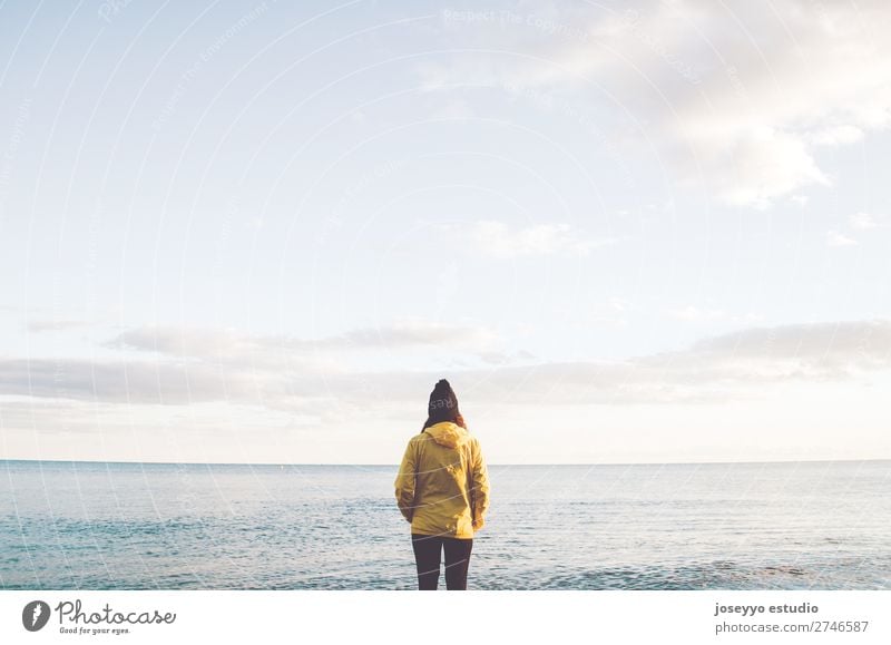 Frau am Strand mit Blick auf den Horizont Lifestyle Leben Erholung Ausflug Freiheit Sonne Winter Sport Sitzung 30-45 Jahre Erwachsene Natur Küste Mode Jacke