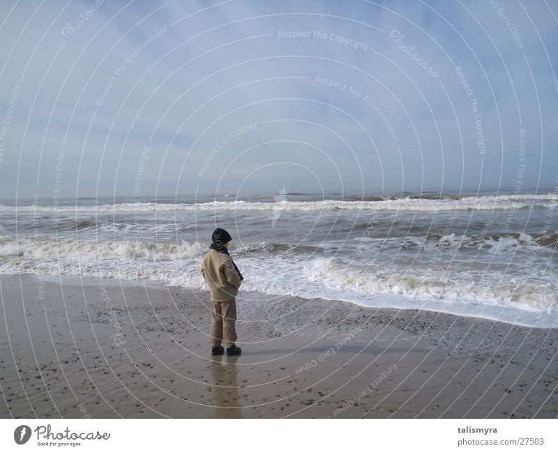 Frühjahr an der Nordsee Kind warm eingemummelt am Strand Wasser Sand Himmel