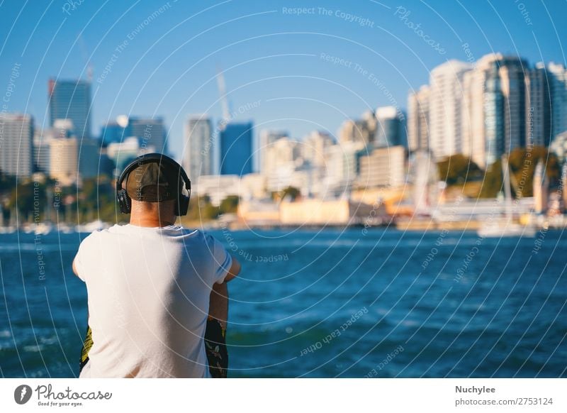 Ein Mann, der am Strand sitzt und Musik hört. Lifestyle Stil Glück Erholung Ferien & Urlaub & Reisen Sommer Meer Mensch Erwachsene Natur Gebäude hören sitzen