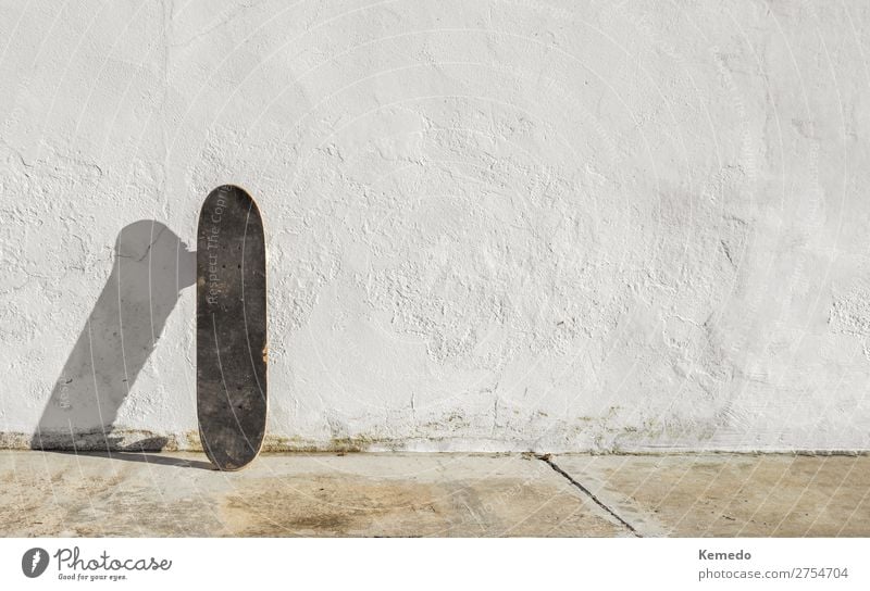 Skateboard auf einer verfallenen weißen Wand an einem sonnigen Tag. Lifestyle Leben harmonisch Erholung Freizeit & Hobby Reiten Abenteuer Freiheit Sommer