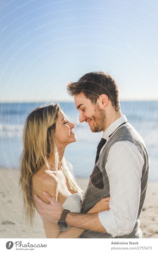 Zärtlich küssendes Brautpaar im Sonnenlicht Paar Hochzeit Strand umarmend Engagement Zufriedenheit Valentinsgruß Genuss verliebt Meereslandschaft stehen