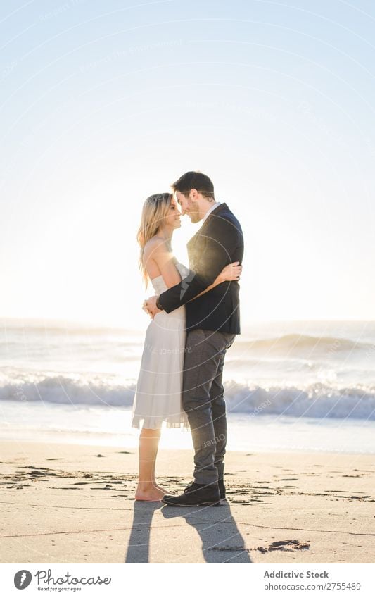 Zärtlich küssendes Brautpaar im Sonnenlicht Paar Hochzeit Strand umarmend Engagement Zufriedenheit Valentinsgruß Genuss verliebt Meereslandschaft stehen