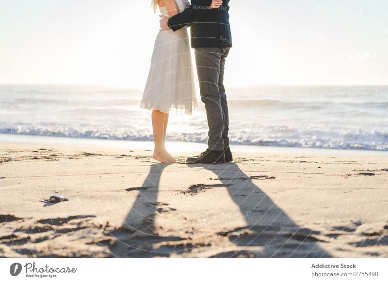 Pflanzen Sie Braut und Bräutigam auf Sand. Paar striegeln Strand stehen Fuß verliebt Jungvermählte Natur Küste Sonnenlicht Partnerschaft Beautyfotografie Barfuß