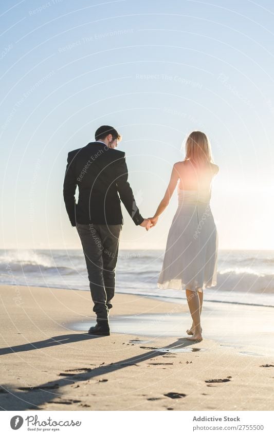 Romantische Braut und Bräutigam beim Spaziergang am Strand Paar striegeln verliebt romantisch Partnerschaft Händchenhalten träumen Jugendliche Meer Engagement