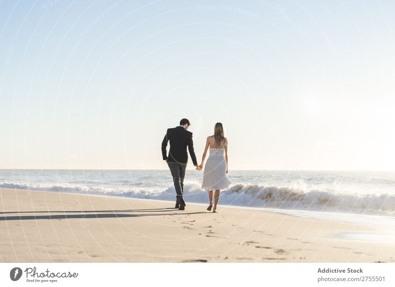 Romantische Braut und Bräutigam beim Spaziergang am Strand Paar striegeln verliebt romantisch Partnerschaft Händchenhalten träumen Jugendliche Meer Engagement