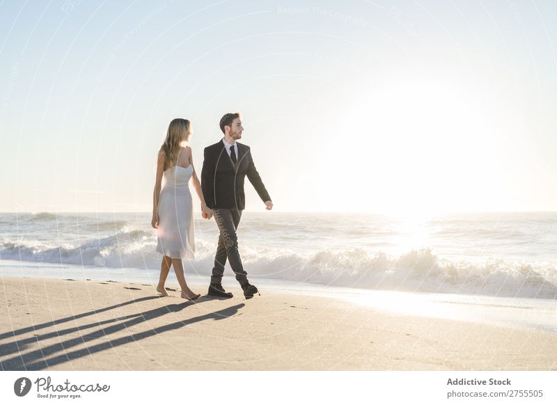 Romantische Braut und Bräutigam beim Spaziergang am Strand Paar striegeln verliebt romantisch Partnerschaft Händchenhalten träumen Jugendliche Meer Engagement