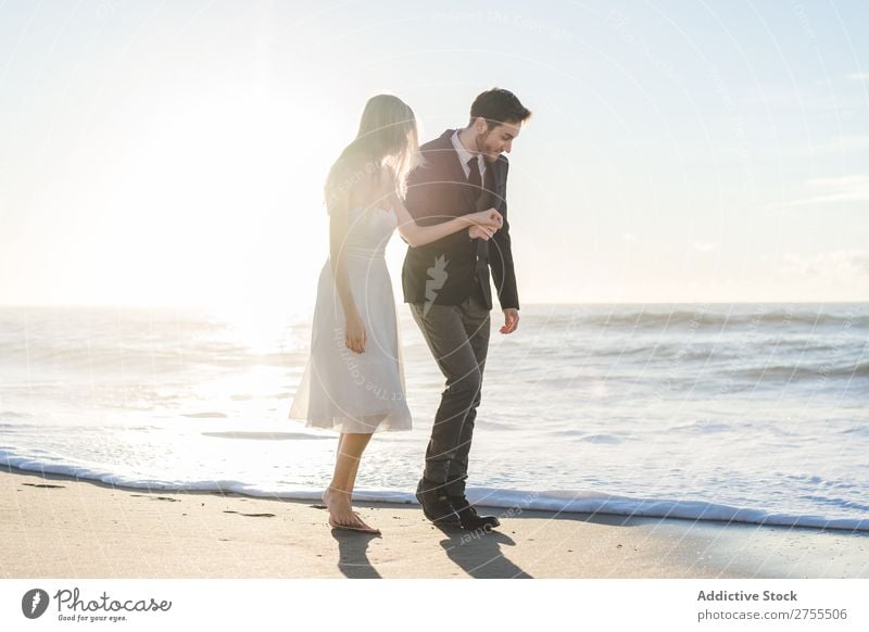 Romantische Braut und Bräutigam beim Spaziergang am Strand Paar striegeln verliebt romantisch Partnerschaft Händchenhalten träumen Jugendliche Meer Engagement