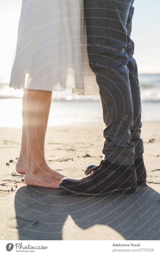 Pflanzen Sie Braut und Bräutigam auf Sand. Paar striegeln Strand stehen Fuß verliebt Jungvermählte Natur Küste Sonnenlicht Partnerschaft Beautyfotografie Barfuß