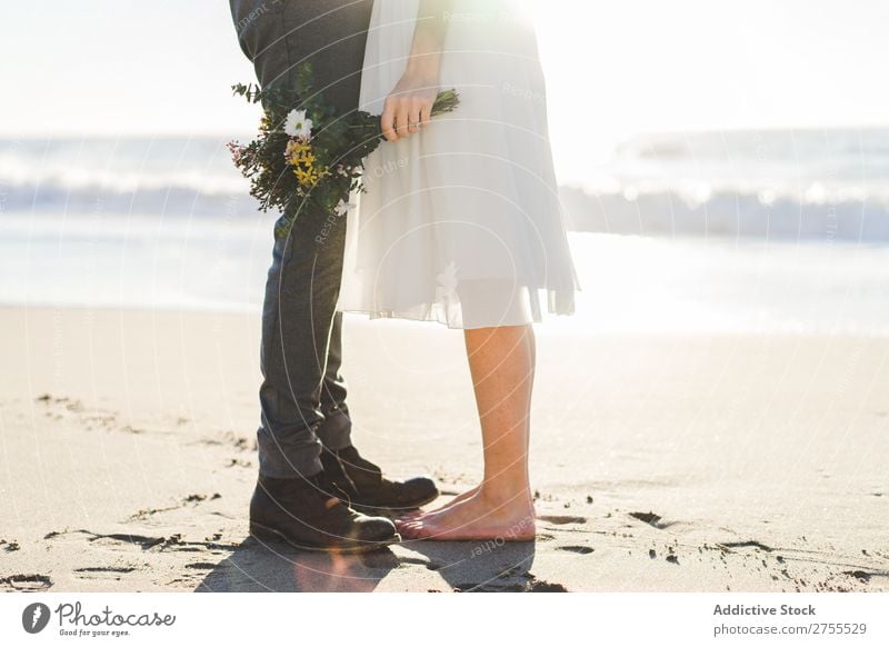 Pflanzenbraut mit Blumenstrauß, der den Bräutigam umfasst. Paar hochzeitlich Umarmen Feste & Feiern Hochzeit Natur romantisch Strand reisend Liebe rustikal