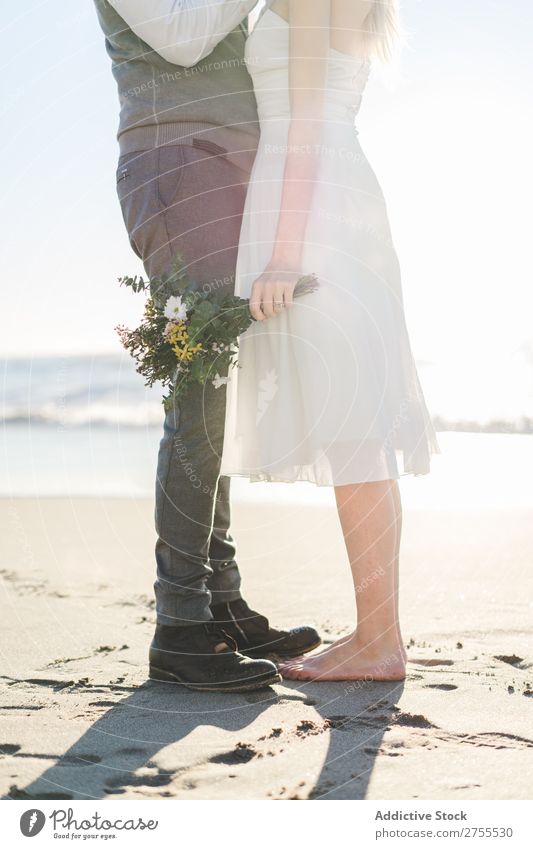 Pflanzenbraut mit Blumenstrauß, der den Bräutigam umfasst. Paar hochzeitlich Umarmen Feste & Feiern Hochzeit Natur romantisch Strand reisend Liebe rustikal