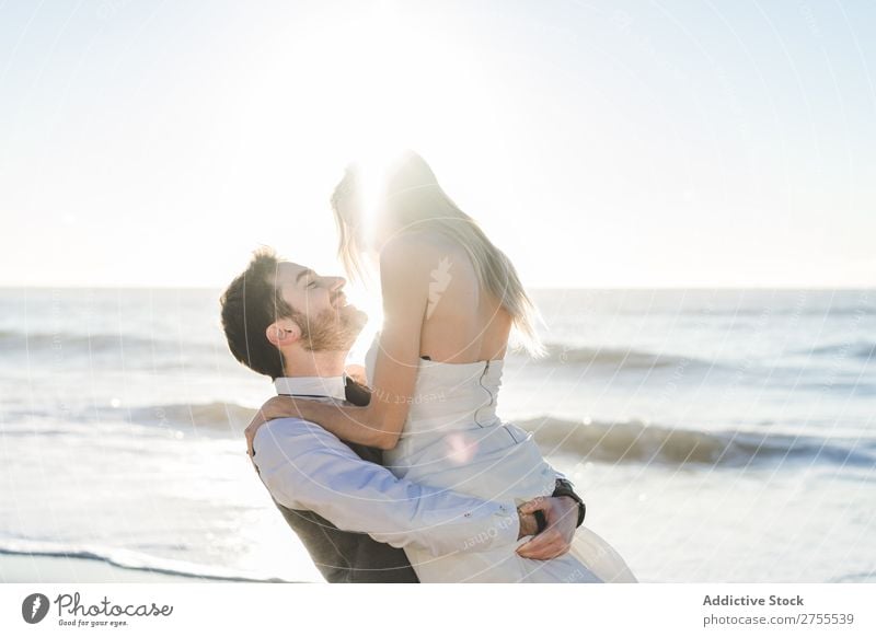 Wunderbares Brautpaar beim Küssen am Strand Paar Hochzeit hochzeitlich tragen verliebt genießen amourös umarmend Liebe Seeküste romantisch Zusammensein