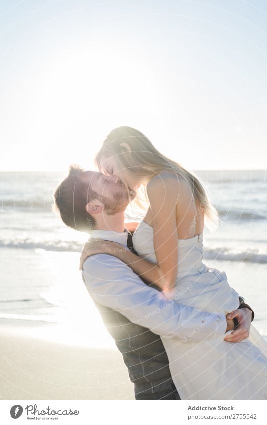 Wunderbares Brautpaar beim Küssen am Strand Paar Hochzeit hochzeitlich tragen verliebt genießen amourös umarmend Liebe Seeküste romantisch Zusammensein