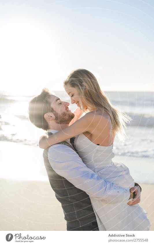 Wunderbares Brautpaar beim Küssen am Strand Paar Hochzeit hochzeitlich tragen verliebt genießen amourös umarmend Liebe Seeküste romantisch Zusammensein