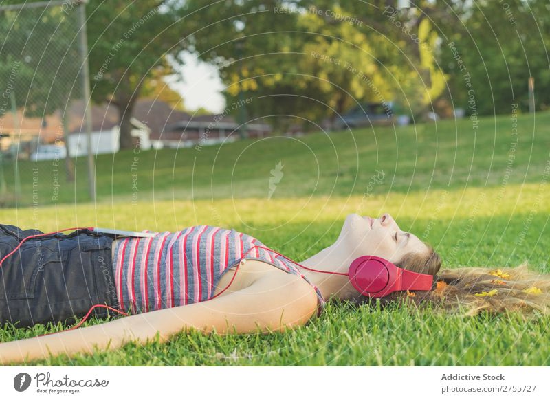 Mädchen mit Gadgets auf dem Rasen Frau Kopfhörer Erholung feminin Musik träumen Blume Wiese Entertainment Schüler Park Sommer Freiheit Zufriedenheit Natur hören