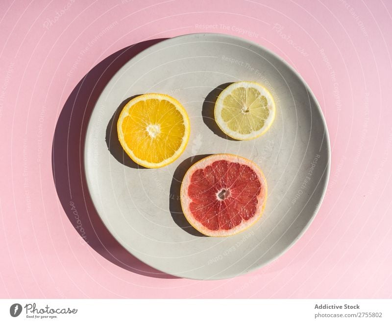 Zitrusscheiben auf rundem Teller Scheiben Zitrusfrüchte Sortiment frisch minimalistisch Gesundheit saftig mischen Grapefruit Zitrone natürlich Diät Orange