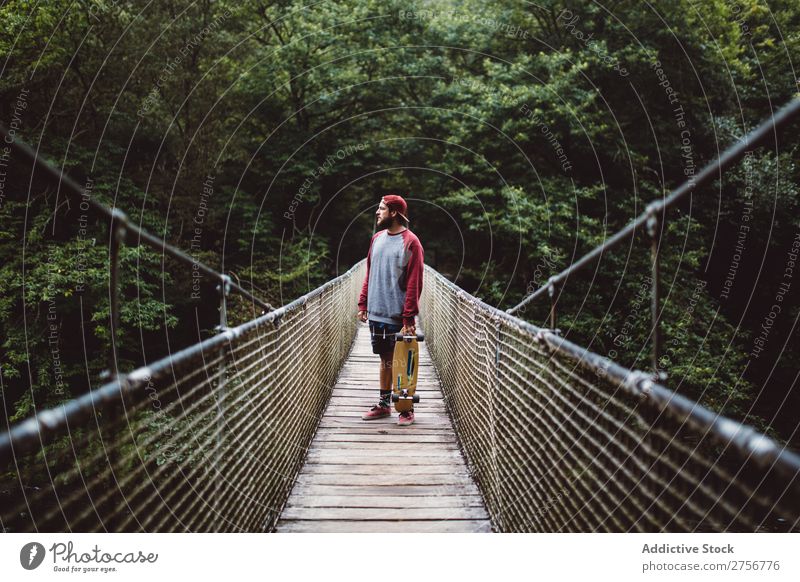 Mann mit Skateboard auf der Waldbrücke posierend Freude Schlittschuhlaufen Mensch Sport extrem Bewegung Energie Straße Aktion Ausritt Gleichgewicht Lifestyle