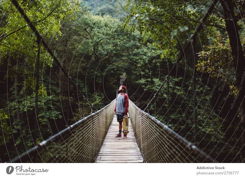 Mann mit Skateboard auf der Waldbrücke posierend Freude Schlittschuhlaufen Mensch Sport extrem Bewegung Energie Straße Aktion Ausritt Gleichgewicht Lifestyle