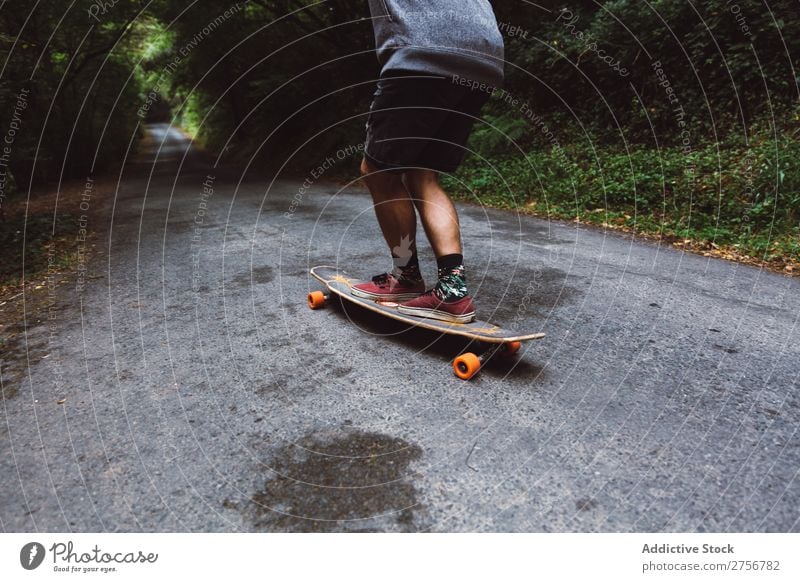 Getreidemann auf dem Skateboard auf der Forststraße Mann Wald Freude Schlittschuhlaufen Mensch Sport extrem Bewegung Energie Straße Aktion Ausritt Gleichgewicht