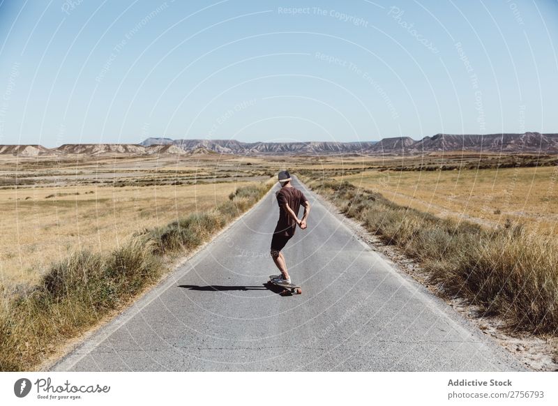 Mann fährt Skateboard auf der Präriestraße Straße Ferien & Urlaub & Reisen Lifestyle Mensch Erwachsene Natur Abenteuer Ausflug Tourist Landschaft Reiten