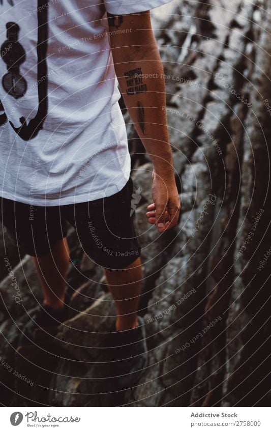 Crop Mann mit Tattoo auf Stein stehen Arme Erfolg Felsen Mensch Freiheit Aussicht Natur Landschaft Berge u. Gebirge Ferien & Urlaub & Reisen Klippe Gipfel Top