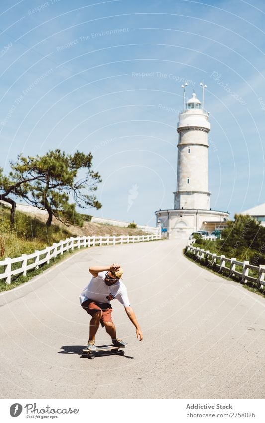 Mann Skateboarding am Leuchtfeuer Skateboarderin Reiten Asphalt Leuchtturm Seeküste Sport Lifestyle Schlittschuhlaufen Schlittschuhe extrem Sonnenstrahlen