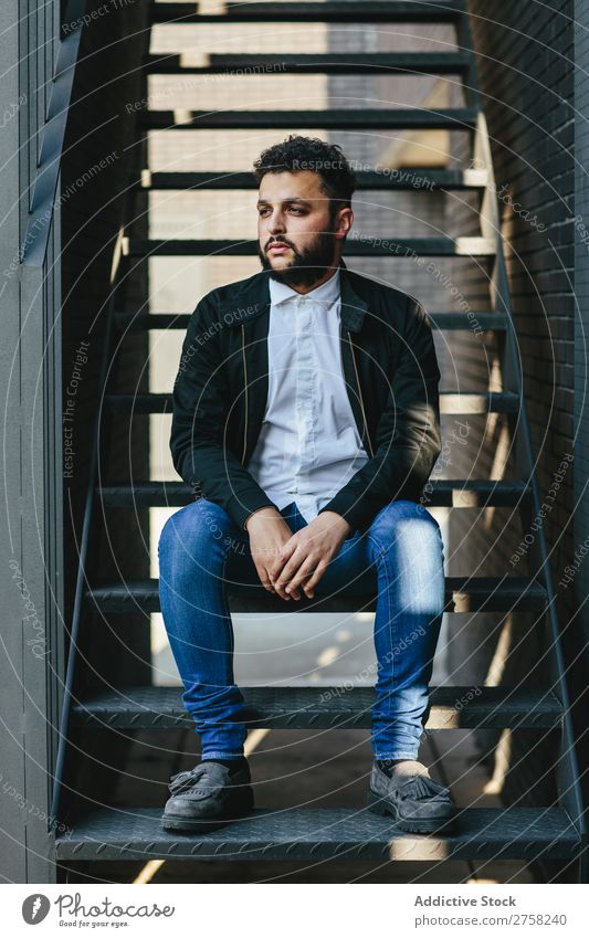 Nachdenklicher Mann sitzt auf der Treppe stylisch besinnlich nachdenklich in die Kamera schauen Sitzen selbstbewusst jung cool Person Porträt modern Model