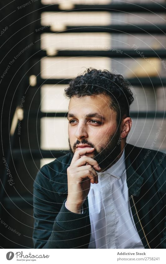 Nachdenklicher Mann sitzt auf der Treppe stylisch besinnlich nachdenklich in die Kamera schauen Sitzen selbstbewusst jung cool Person Porträt modern Model