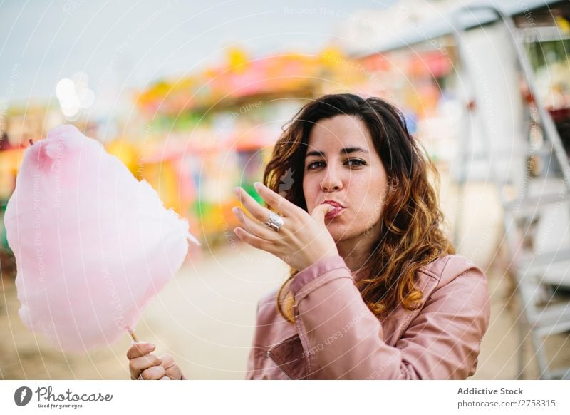 Frau mit Zuckerwatte im Park Kinderkarussell Person rosa hübsch süß Lebensmittel essen Spaß Lifestyle Porträt jung Lächeln Beteiligung Snack außerhalb weich