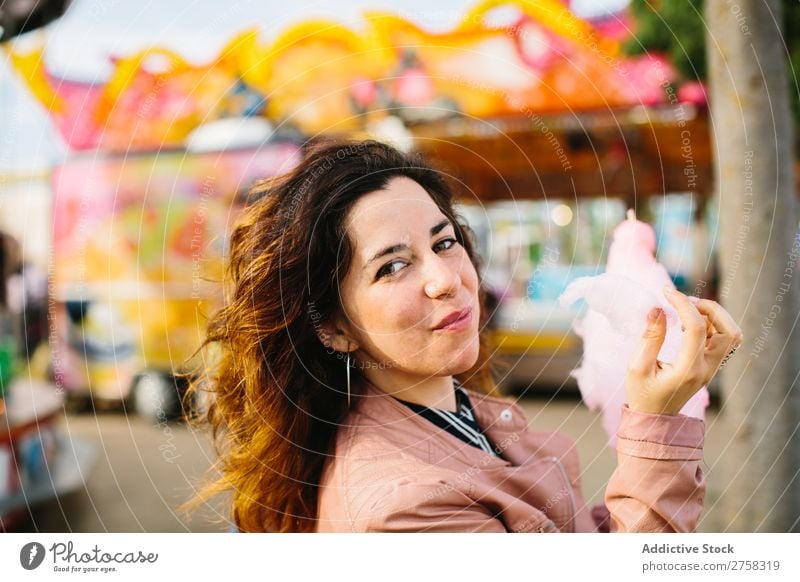 Frau mit Zuckerwatte im Park Kinderkarussell Person rosa hübsch süß Lebensmittel essen Spaß Lifestyle Porträt jung Lächeln Beteiligung Snack außerhalb weich