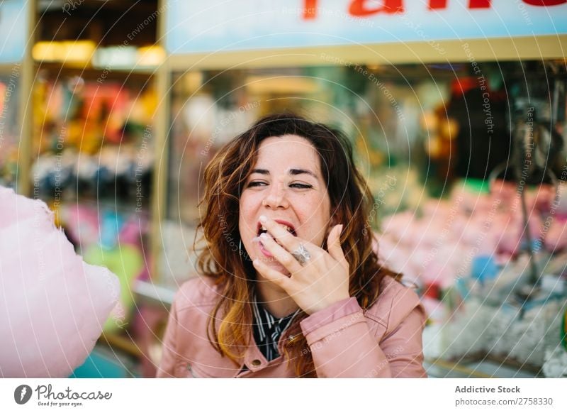 Frau mit Zuckerwatte im Park Kinderkarussell Person rosa hübsch süß Lebensmittel essen Spaß Lifestyle Porträt jung Lächeln Beteiligung Snack außerhalb weich