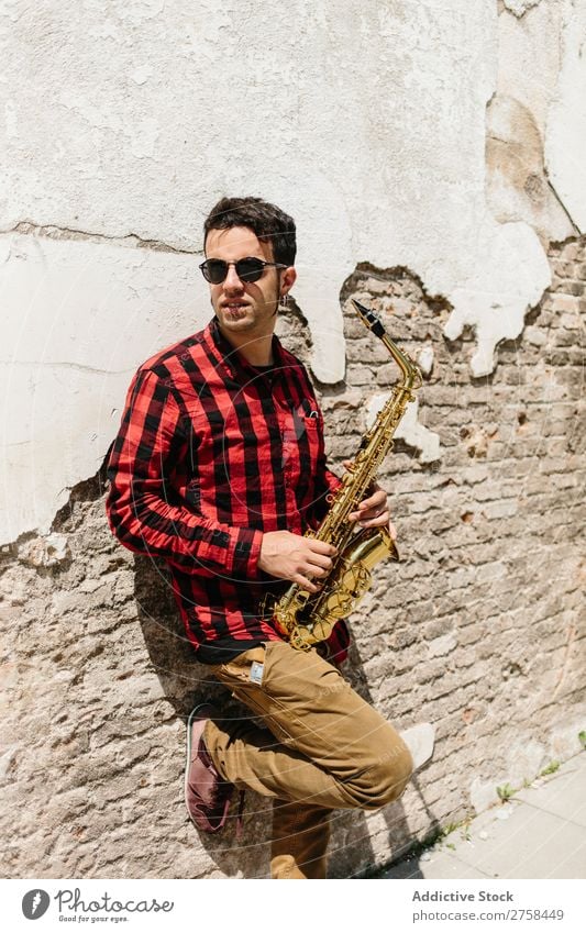 Cooler Musiker mit Saxophon Mann Sonnenbrille selbstbewußt Coolness Wand Jugendliche Jazz Instrument Musical Leistung Saxophonspieler Mensch Spieler Artist