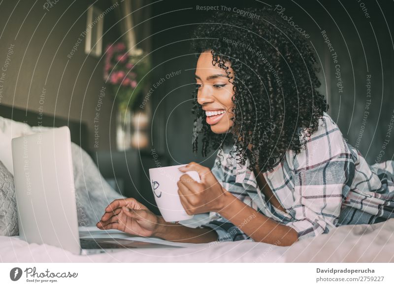 schöne schwarze Frau auf dem Bett mit Laptop und Tasse Kaffee Notebook Computer Lächeln Porträt Nahaufnahme Technik & Technologie Internet WiFi Gerät Mitteilung