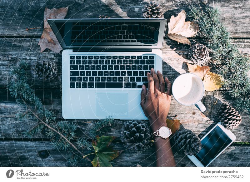 Computer auf einem Holztisch mit Kaffee und Kiefern im Freien Weihnachten & Advent Notebook Technik & Technologie Hand Arme beobachten Mobile Telefon Geschenk