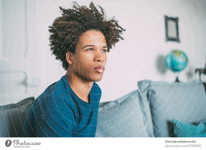 Porträt eines jungen nachdenklichen gemischtrassigen Mannes, der auf dem Sofa sitzt. schwarz Jugendliche Mensch Rennsport Amerikaner Afrikanisch