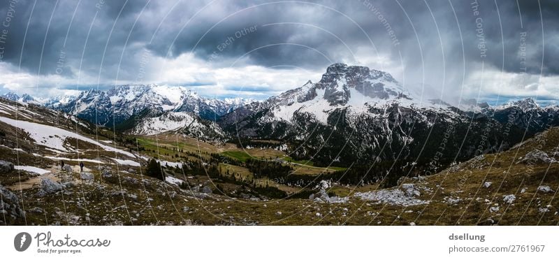 Ausblick auf schneebedeckte Felsen mit düsteren Wolken weite Ausflug Wanderausflug Wandertag Weg Zentralperspektive Schnee Sonnenlicht Urelemente