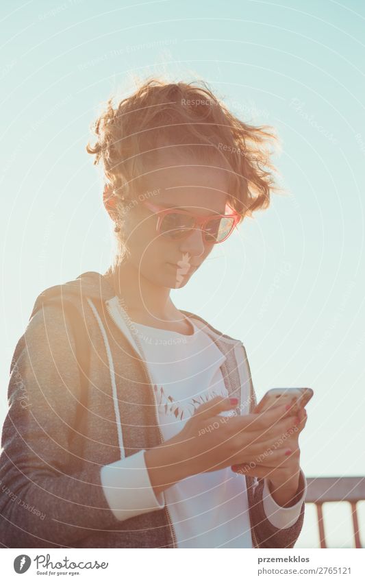 Mädchen mit Telefon, die auf den Bildschirm schauen, der im Freien steht. Lifestyle Freude Glück Ferien & Urlaub & Reisen Sommer PDA Fotokamera