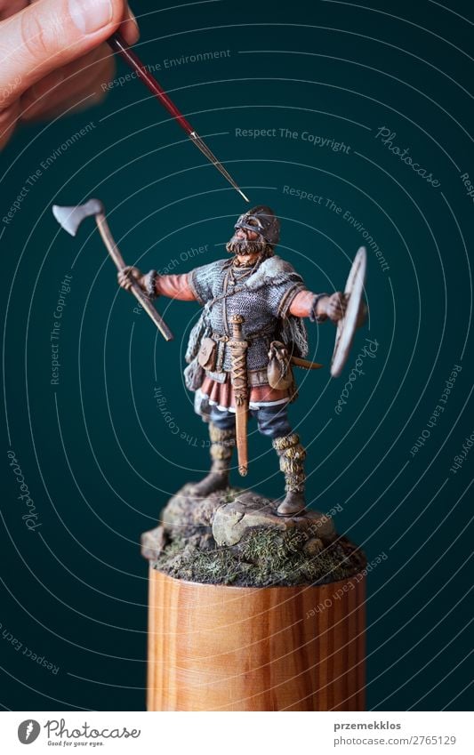 Mann malt eine kleine Wikingerfigur. Freizeit & Hobby Hand schließen Entwurf Figur Miniatur Model Farbe Pinselblume Malerei Perfektion Farbfoto Detailaufnahme