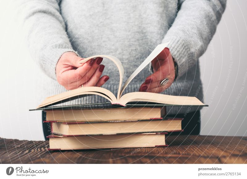 Frau blättert Seiten des Buches auf dem Tisch im Antiquariat um. Lifestyle kaufen Erholung Freizeit & Hobby lesen Schule lernen Mensch Erwachsene Jugendliche 1