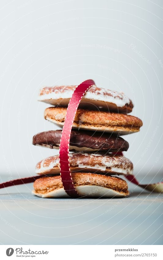 Ein paar Lebkuchenplätzchen in rotem Band auf Holztisch verpackt. Kuchen Dessert Ernährung Essen Diät Tisch Schnur genießen lecker braun backen Bäckerei Biskuit