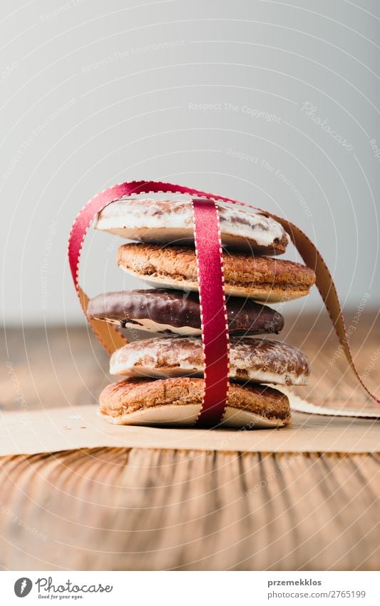 Ein paar Lebkuchenplätzchen in rotem Band auf Holztisch verpackt. Dessert Ernährung Essen Diät Tisch Schnur genießen lecker braun backen Bäckerei Biskuit