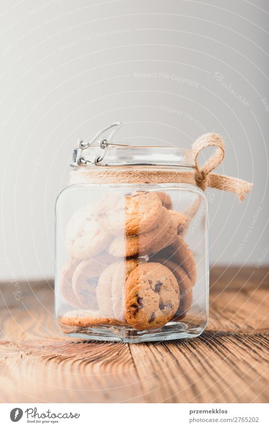 Großes Glas mit Haferplätzchen gefüllt, das auf einem Holztisch steht. Dessert Ernährung Essen Diät Lifestyle Tisch genießen lecker braun backen Bäckerei