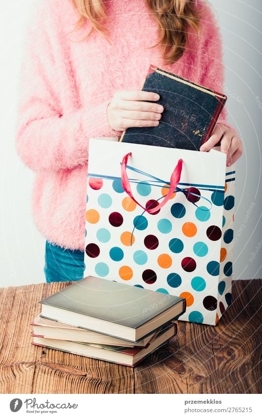 Junges Mädchen, das die Bücher in eine Papiertasche im Buchladen legt. Lifestyle Erholung Freizeit & Hobby lesen Schule lernen Mensch Frau Erwachsene